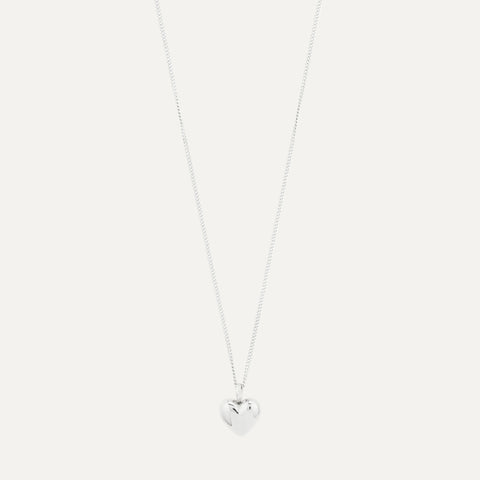 A delicate silver chain necklace with a small, polished heart-shaped pendant, shown against a solid white background.