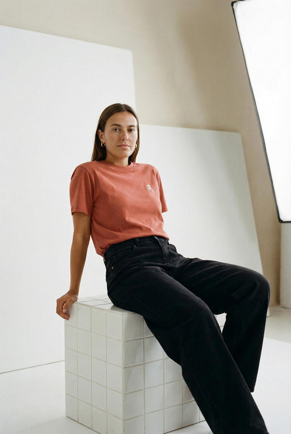 a_woman_wearing_rust_t-shirt_with_small_white_embroidered_logo_from_almost_summer