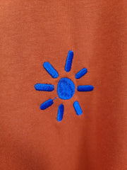 blue sun on dark orange organic cotton unisex tshirt te koop in de webshop van Almost Summer Amsterdam